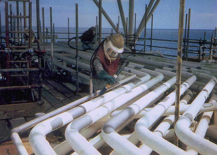 Operator using garnet abrasive blasting for surface preparation of pipelines